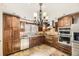 Beautiful kitchen featuring wooden cabinets, stainless steel appliances, stone countertops, and stylish lighting at 27 Buckthorn Dr, Littleton, CO 80127