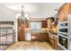 Well-appointed kitchen with wooden cabinetry, stainless steel appliances, and unique stone tile flooring at 27 Buckthorn Dr, Littleton, CO 80127