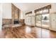 Bright living room with brick fireplace, hardwood floors, and sliding glass doors to outdoor deck at 27 Buckthorn Dr, Littleton, CO 80127