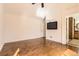 Bright primary bedroom featuring hardwood floors and a mounted television at 27 Buckthorn Dr, Littleton, CO 80127