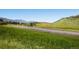 Scenic view of a country road with rolling hills and lush green fields, ideal for a peaceful drive at 27 Buckthorn Dr, Littleton, CO 80127