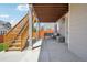 Cozy covered patio area with concrete flooring, outdoor furniture, and stairs leading to the yard at 9759 Waco St, Commerce City, CO 80022