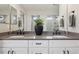 Bathroom featuring dual sinks, a large mirror, and modern hardware at 9759 Waco St, Commerce City, CO 80022