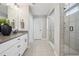 Bright bathroom with double vanity, white cabinets, and a glass shower with gray tile surround at 9759 Waco St, Commerce City, CO 80022