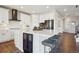 Contemporary kitchen with white cabinets, a large island with seating, and stainless steel appliances at 9759 Waco St, Commerce City, CO 80022