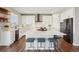Modern kitchen features white cabinets, quartz counters, stainless appliances, and a large island with seating at 9759 Waco St, Commerce City, CO 80022