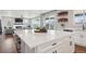 Open-concept kitchen with white cabinets, an island with seating, connecting to the bright living room at 9759 Waco St, Commerce City, CO 80022