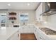 Well-lit kitchen featuring white cabinets, quartz countertops, and open shelving at 9759 Waco St, Commerce City, CO 80022