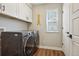 Laundry room featuring a side-by-side washer and dryer and white cabinets at 9759 Waco St, Commerce City, CO 80022