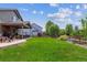 Expansive backyard with a covered patio, lush lawn, and mature trees at 16662 W 61St Pl, Arvada, CO 80403