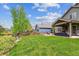 Lush backyard with green grass, mature trees, and a covered patio for outdoor enjoyment at 16662 W 61St Pl, Arvada, CO 80403