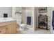 Well-lit bathroom with a vanity, toilet, and glass-enclosed shower, plus modern shelving at 16662 W 61St Pl, Arvada, CO 80403
