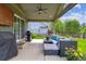 Covered outdoor patio with comfortable seating, a grill, and a view of the lush backyard at 16662 W 61St Pl, Arvada, CO 80403