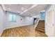 Finished basement with wood-look flooring, bright windows, and a staircase leading to the upper level at 9567 W 107Th Dr, Broomfield, CO 80021