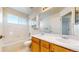 Bathroom featuring a tub and shower, tile floors, and a double vanity with wood cabinets at 9567 W 107Th Dr, Broomfield, CO 80021