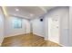 Bedroom featuring a bright, connected bathroom, wood-look flooring and a large window at 9567 W 107Th Dr, Broomfield, CO 80021