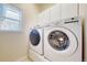 Modern laundry area with front-loading washer and dryer under a large window at 9567 W 107Th Dr, Broomfield, CO 80021