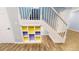 Bright staircase with white railings, colorful built-in shelving and wood-look flooring at 9567 W 107Th Dr, Broomfield, CO 80021