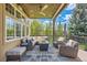 A covered back deck features outdoor furniture, a ceiling fan, and beautiful views at 7083 Turweston Ln, Castle Pines, CO 80108