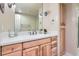 Bathroom features wood cabinets, a white countertop, decorative lighting, and a large mirror at 7083 Turweston Ln, Castle Pines, CO 80108