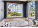 Bright bathroom features a luxurious soaking tub under a large window with a scenic view at 7083 Turweston Ln, Castle Pines, CO 80108