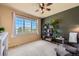 Cozy bedroom features a modern ceiling fan, a large window, and stylish decor at 7083 Turweston Ln, Castle Pines, CO 80108