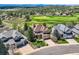 Aerial view of a tan and stone two-story home and golf course community at 7083 Turweston Ln, Castle Pines, CO 80108