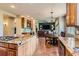 Spacious kitchen with island cooktop that flows into dining area and Gathering room at 7083 Turweston Ln, Castle Pines, CO 80108