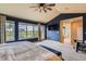 Bright main bedroom features large windows with picturesque outdoor view and modern ceiling fan at 7083 Turweston Ln, Castle Pines, CO 80108