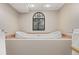 Relaxing bathroom featuring a soaking tub, decorative window accents, and warm neutral tones at 12500 Meade Ct, Broomfield, CO 80020