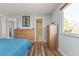 Bedroom featuring natural light, light blue walls, wood laminate flooring, and an ensuite bathroom at 12500 Meade Ct, Broomfield, CO 80020
