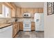 Kitchen featuring light wood cabinets, a large sink window, and white appliances at 12500 Meade Ct, Broomfield, CO 80020