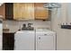Functional laundry room with washer, dryer, overhead cabinets and hanging space for convenience at 12500 Meade Ct, Broomfield, CO 80020
