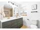 Modern bathroom featuring dual sinks, stylish mirrors, a toilet, and elegant fixtures at 544 S Victor Way, Aurora, CO 80012