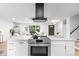 Bright kitchen features stainless steel appliances, a large island with quartz countertops and modern vent hood at 544 S Victor Way, Aurora, CO 80012
