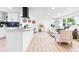 Open-concept kitchen and living space with modern white cabinetry, stainless steel appliances, and stylish furnishings at 544 S Victor Way, Aurora, CO 80012