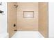 Tiled shower boasts neutral accents, built-in niche, and new showerhead for a spa-like experience at 544 S Victor Way, Aurora, CO 80012