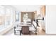 Bright dining room with sliding glass doors, wood table, white upholstered chairs, and modern kitchen at 2471 Quitman St, Denver, CO 80212