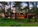 Beautiful exterior view of a home surrounded by tall trees and a green landscape at twilight at 2907 Hiwan Dr, Evergreen, CO 80439