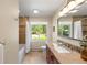 Bright bathroom features a large mirror, granite vanity, and shower-tub combination at 2907 Hiwan Dr, Evergreen, CO 80439