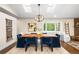 Dining room with a wooden table, blue chairs, a modern chandelier, and natural light from the skylights at 2907 Hiwan Dr, Evergreen, CO 80439