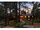 Inviting single-story home with stone accents and warm interior lighting at dusk at 2907 Hiwan Dr, Evergreen, CO 80439