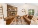 Cozy living room features a stone fireplace, leather sofa, patterned rug, and plenty of natural light at 2907 Hiwan Dr, Evergreen, CO 80439