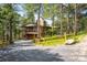 Spacious two-story home with an upper deck and stone chimney surrounded by trees at 2907 Hiwan Dr, Evergreen, CO 80439