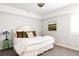 Bedroom with white bedding, pillows, green bedside table, and contemporary artwork at 2540 S Monroe St, Denver, CO 80210