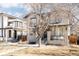 Attractive two-story home showcasing stone accents, a dark roof, a welcoming green entry door, and low maintenance landscaping at 2540 S Monroe St, Denver, CO 80210