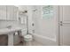 Bright bathroom features white tiled walls, a glass block window, and traditional fixtures at 1111 S Corona St, Denver, CO 80210