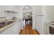 Efficient kitchen with traditional design elements and a view into adjacent dining and living areas at 1111 S Corona St, Denver, CO 80210