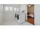 Laundry room features a modern washer and dryer, bright lighting and is adjacent to a bedroom at 1111 S Corona St, Denver, CO 80210