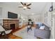 Cozy living room featuring a brick fireplace, hardwood floors, and ample natural light at 1111 S Corona St, Denver, CO 80210